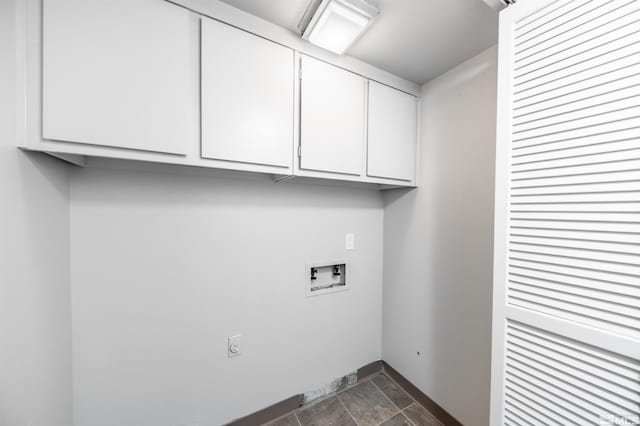 clothes washing area featuring washer hookup, cabinet space, and baseboards