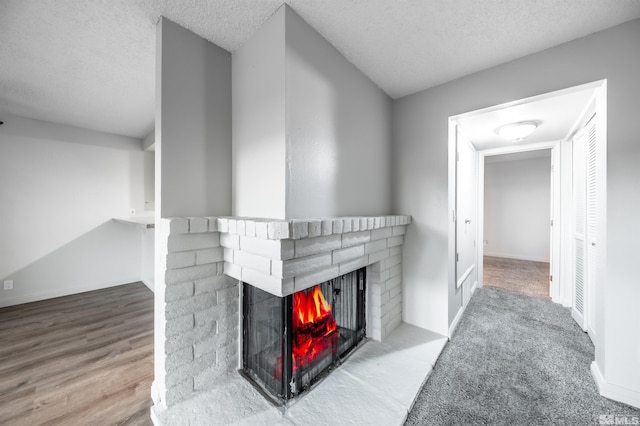 living room with a fireplace, baseboards, and a textured ceiling