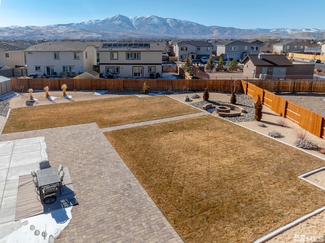 view of yard featuring a mountain view, a fenced backyard, and a residential view