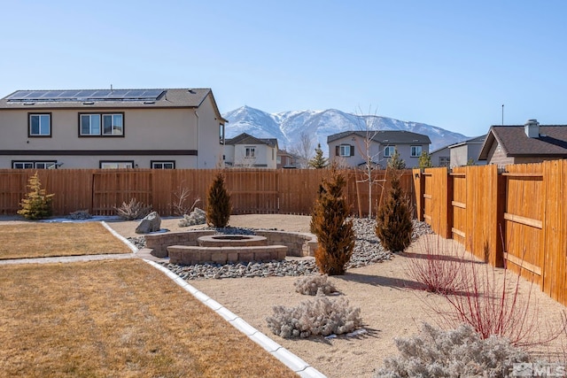 view of yard featuring a fenced backyard, a mountain view, and a fire pit