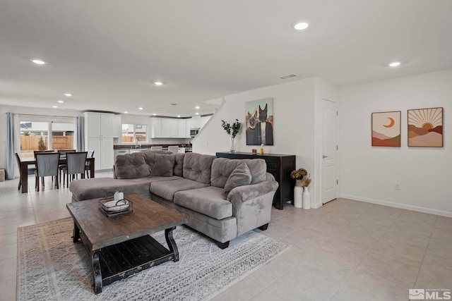 living area with recessed lighting, visible vents, and baseboards