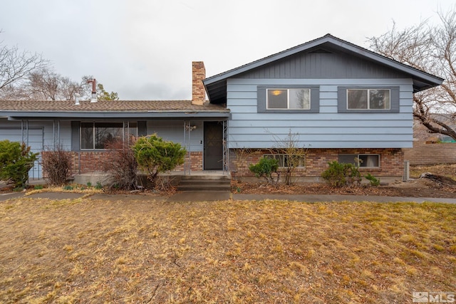 split level home with brick siding and a chimney