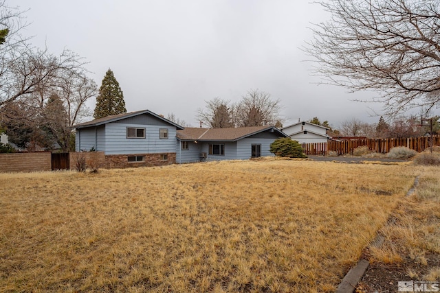 view of front of house with a front lawn and fence