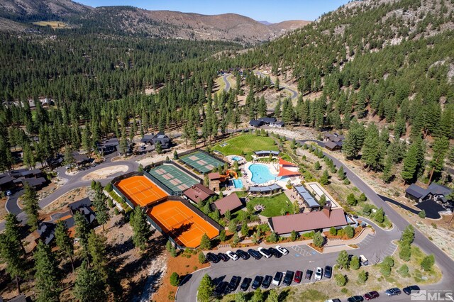 birds eye view of property featuring a forest view and a mountain view