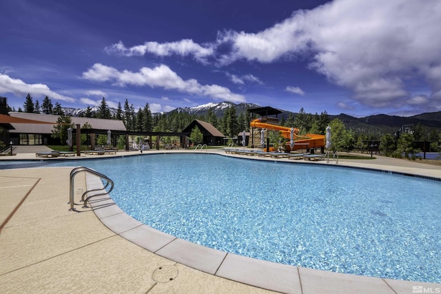 community pool with a mountain view and playground community