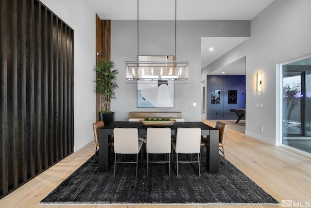 dining room featuring a chandelier, recessed lighting, a high ceiling, wood finished floors, and baseboards