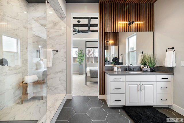 full bath with ceiling fan, tile patterned flooring, vanity, a marble finish shower, and ensuite bath