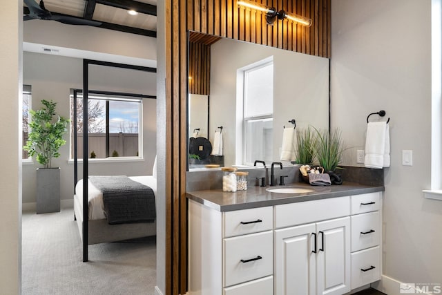 bathroom with baseboards, visible vents, vanity, and ensuite bath