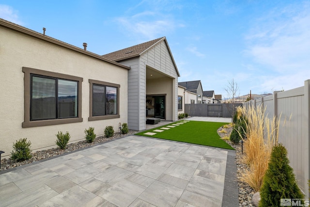 back of house with a patio area, a yard, a fenced backyard, and stucco siding