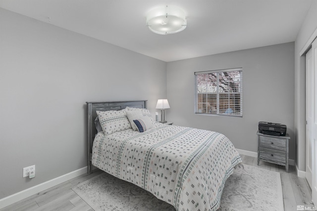 bedroom with light wood finished floors and baseboards