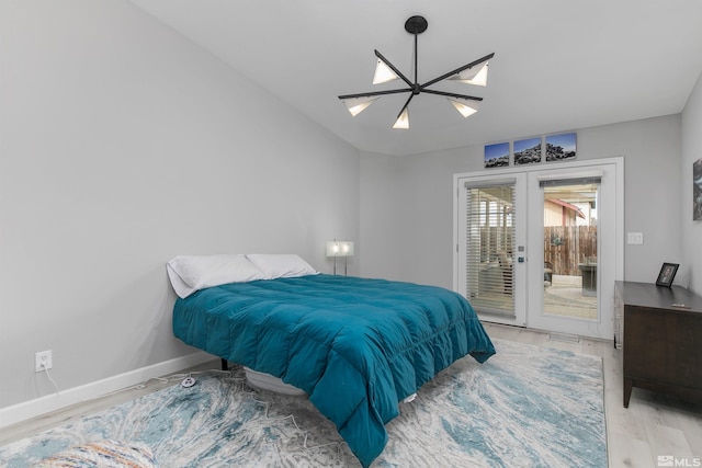 bedroom with a skylight, baseboards, access to outside, french doors, and light wood-style floors