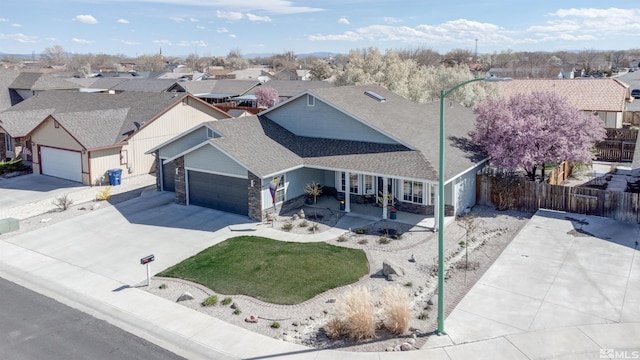 ranch-style house featuring a residential view, stone siding, and fence