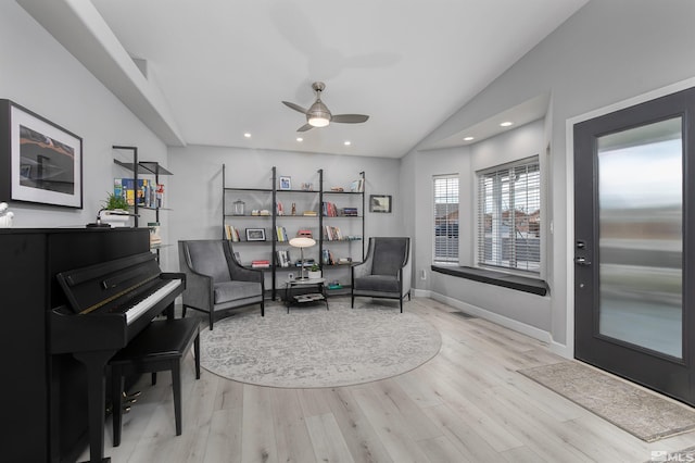 living area featuring lofted ceiling, recessed lighting, visible vents, light wood-style flooring, and baseboards