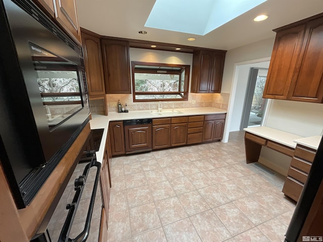 kitchen featuring tasteful backsplash, built in desk, light countertops, and a sink