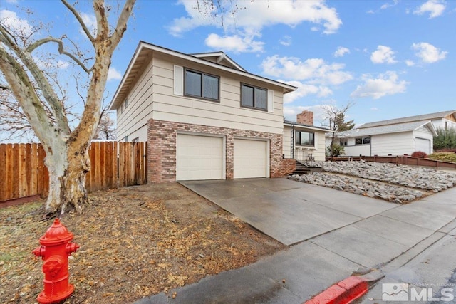 view of front facade featuring a garage, fence, concrete driveway, and brick siding