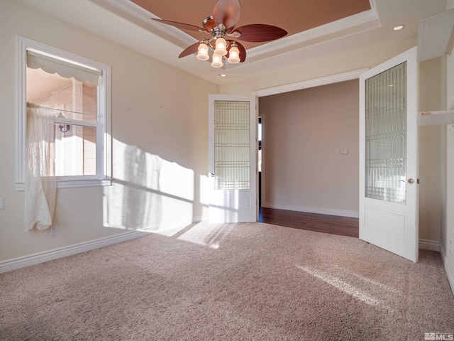 carpeted empty room featuring ceiling fan, recessed lighting, a raised ceiling, and baseboards