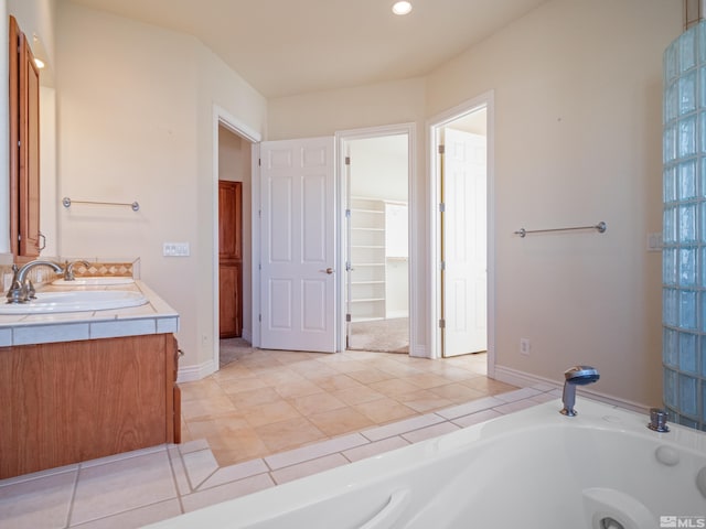 bathroom featuring double vanity, a tub with jets, tile patterned flooring, a sink, and recessed lighting