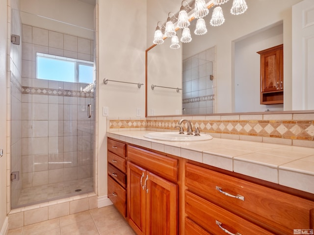 full bath with tile patterned flooring, backsplash, vanity, and a shower stall