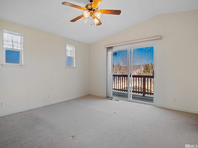 carpeted spare room featuring lofted ceiling, a ceiling fan, and baseboards