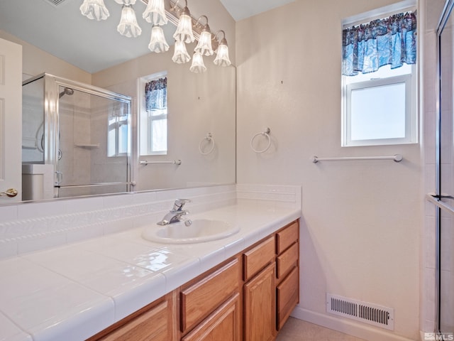 bathroom featuring a stall shower, visible vents, and vanity