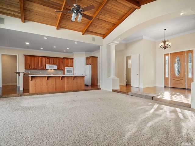 unfurnished living room with wood ceiling, beam ceiling, decorative columns, and baseboards