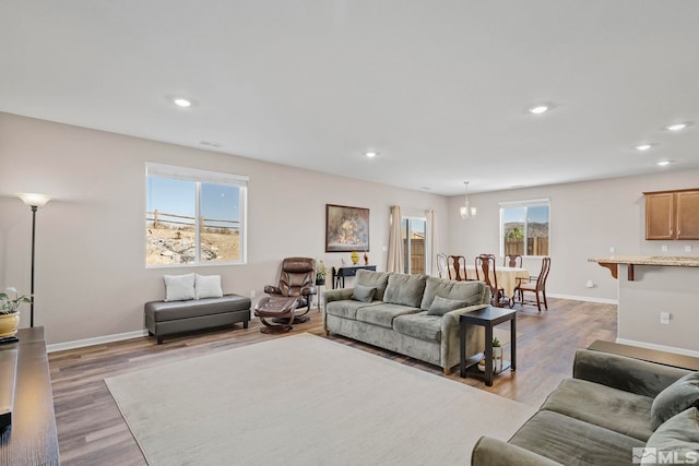 living area with light wood-style flooring, baseboards, and recessed lighting