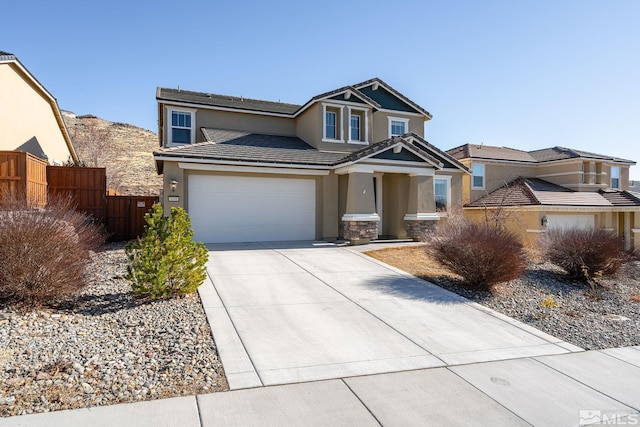 view of front facade featuring a garage, concrete driveway, fence, and stucco siding