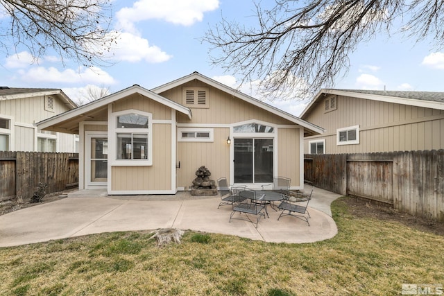 back of house featuring a lawn, a patio area, and a fenced backyard