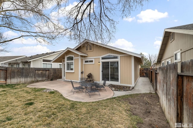 back of property with a fenced backyard, a lawn, and a patio