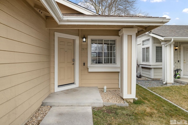 entrance to property with roof with shingles