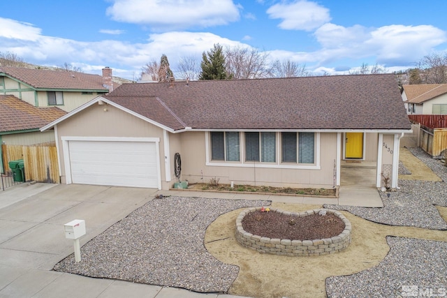 ranch-style house with concrete driveway, a shingled roof, an attached garage, and fence