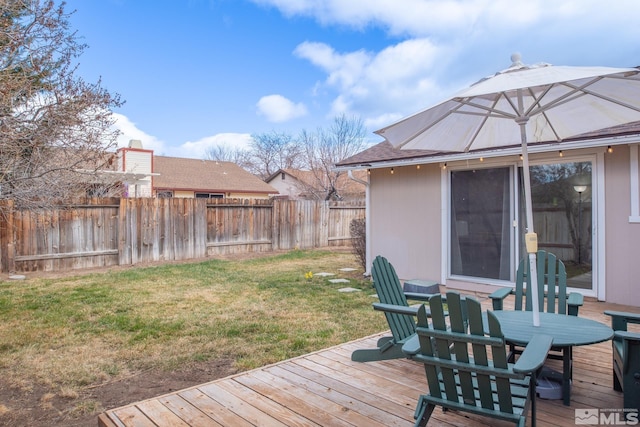 wooden terrace with a yard, outdoor dining space, and fence