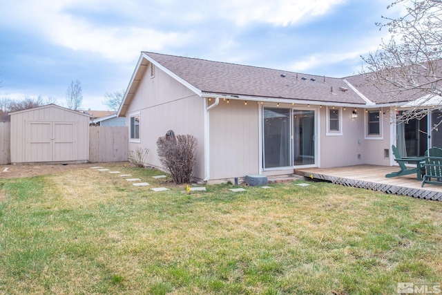 rear view of property with an outbuilding, a lawn, fence, and a shed