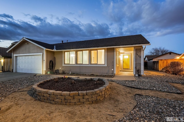 single story home featuring fence, driveway, and an attached garage