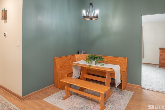 dining room featuring a chandelier, baseboards, and light wood finished floors