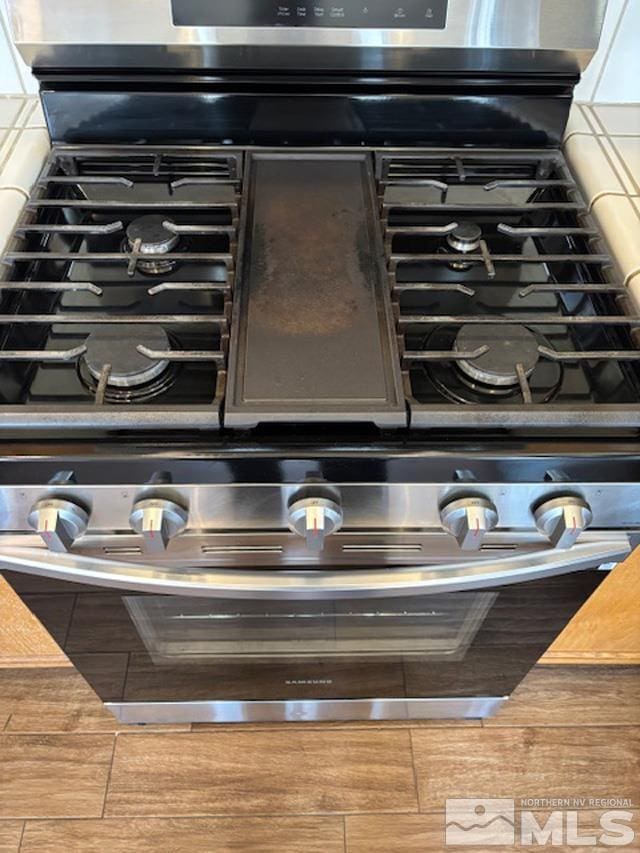 details with stainless steel range with gas cooktop and decorative backsplash