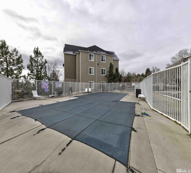 community pool featuring fence and a patio