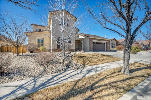 view of front of home with a garage, fence, concrete driveway, and brick siding