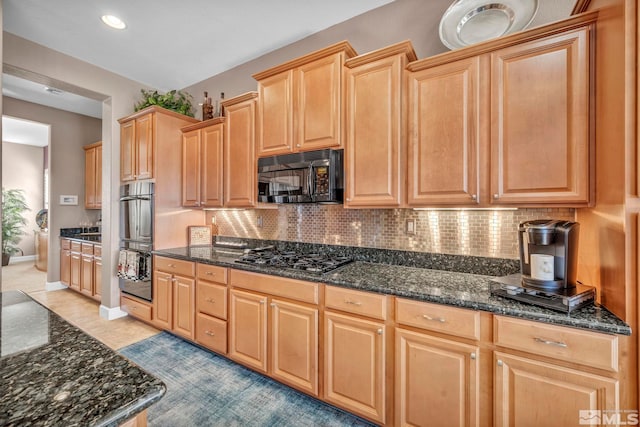 kitchen with black appliances, baseboards, decorative backsplash, and dark stone countertops