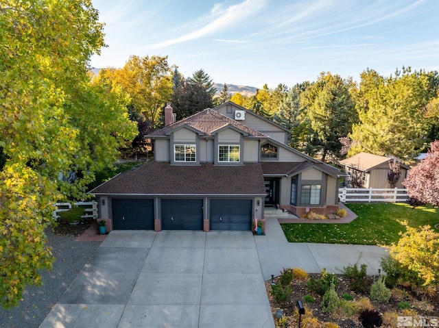 traditional home featuring a garage, concrete driveway, fence, a front lawn, and brick siding