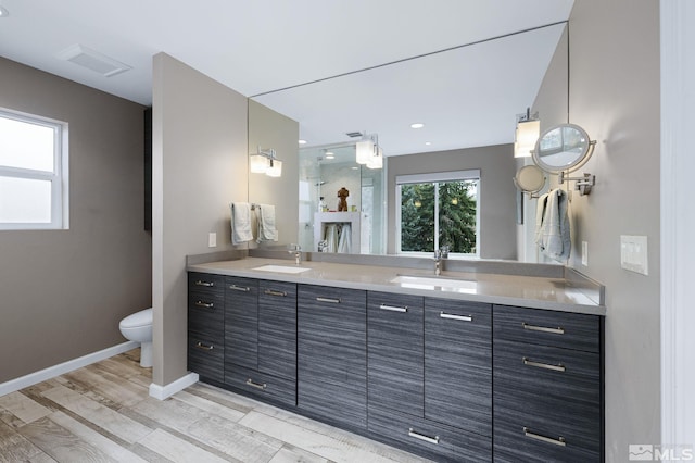 bathroom with double vanity, baseboards, visible vents, and a sink