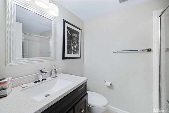 bathroom featuring toilet, visible vents, vanity, baseboards, and a stall shower