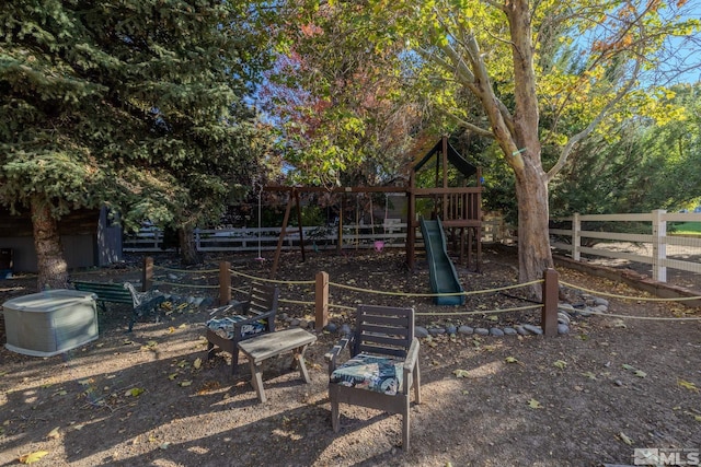 view of yard featuring playground community and fence