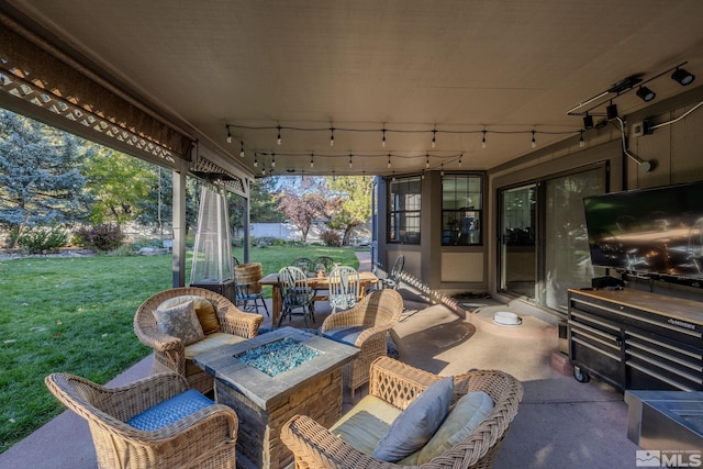 view of patio with an outdoor living space with a fire pit