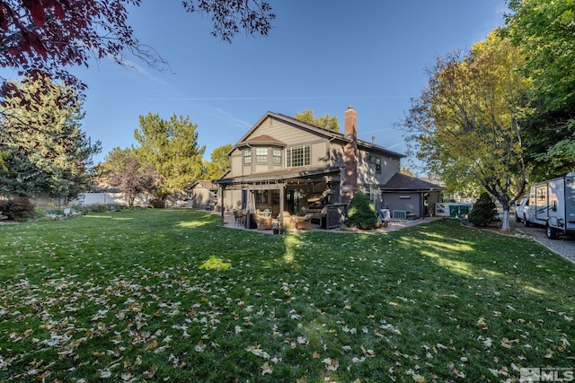 rear view of house featuring a yard and a patio