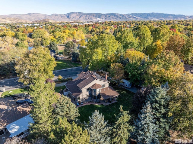 drone / aerial view featuring a mountain view and a view of trees