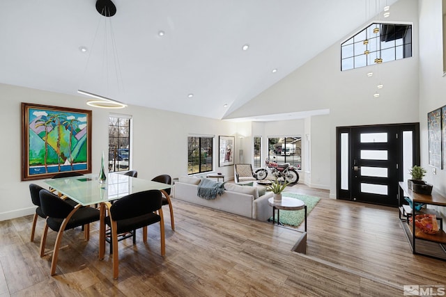 dining area featuring high vaulted ceiling, recessed lighting, baseboards, and wood finished floors