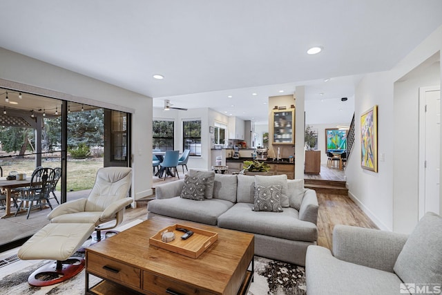 living room featuring baseboards, light wood finished floors, and recessed lighting