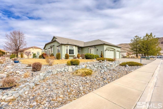 ranch-style house featuring a garage, concrete driveway, and stucco siding