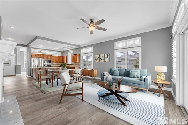 living area with crown molding, recessed lighting, light wood-style flooring, ceiling fan, and baseboards